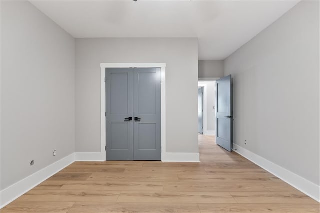 unfurnished bedroom featuring light wood-type flooring and a closet