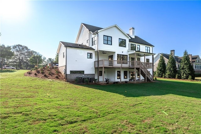 rear view of property featuring ceiling fan, a deck, and a yard