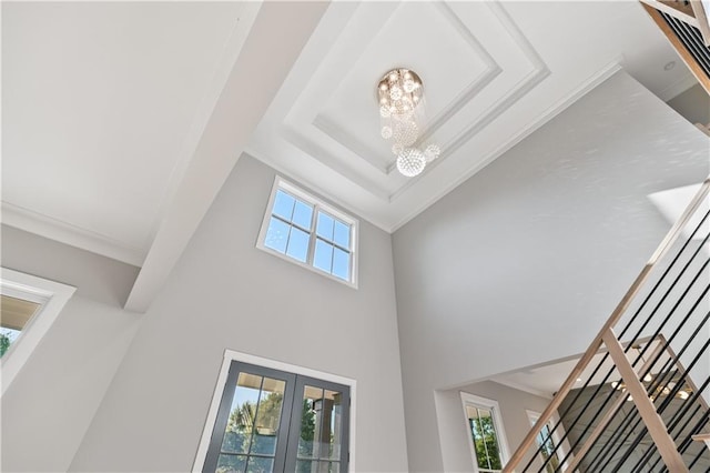 interior details featuring french doors, an inviting chandelier, and crown molding