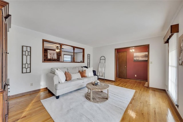 living room featuring light wood-type flooring, ceiling fan, and a wealth of natural light