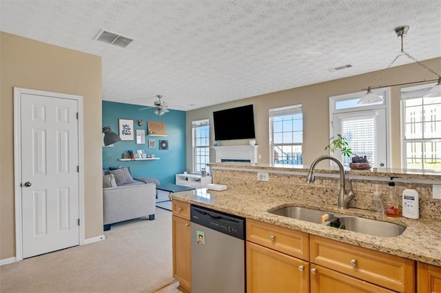 kitchen with decorative light fixtures, light colored carpet, dishwasher, sink, and a textured ceiling