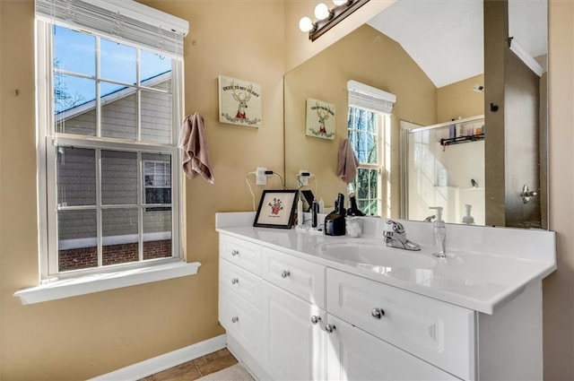 bathroom with lofted ceiling, tile patterned flooring, a shower with door, and vanity