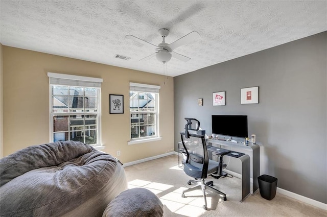 office space featuring ceiling fan, a textured ceiling, and light carpet