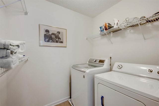 laundry room with separate washer and dryer and a textured ceiling