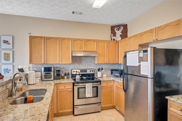 kitchen with sink, a textured ceiling, light brown cabinets, and stainless steel appliances