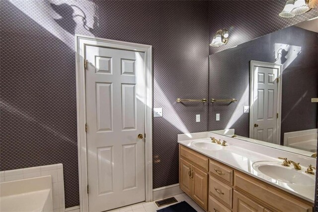 bathroom with vanity, a bathtub, and tile patterned flooring