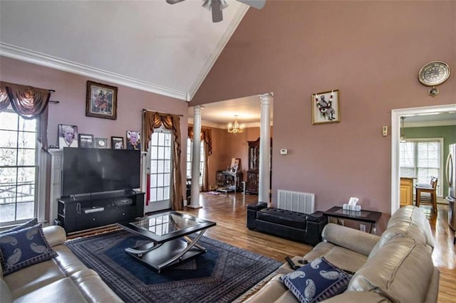 living area with ornamental molding, visible vents, decorative columns, and wood finished floors