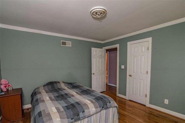 bedroom featuring ornamental molding and wood-type flooring