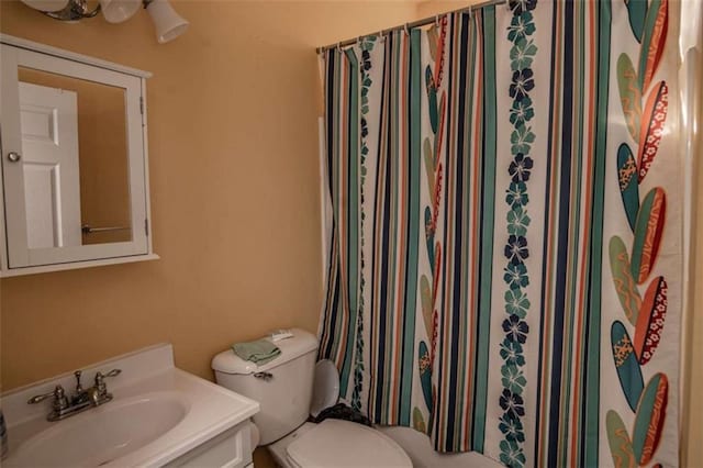 bathroom featuring a shower with curtain, vanity, and toilet