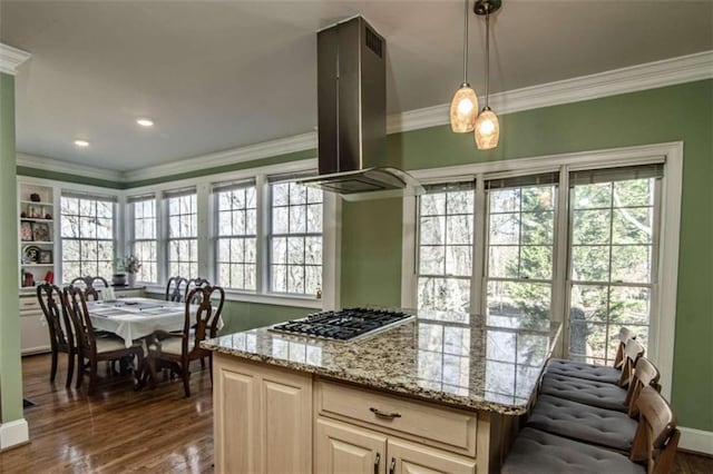 kitchen featuring island range hood, ornamental molding, dark wood-type flooring, stainless steel gas cooktop, and pendant lighting