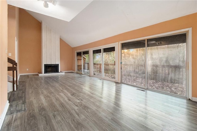 unfurnished living room featuring high vaulted ceiling, a fireplace, and hardwood / wood-style floors