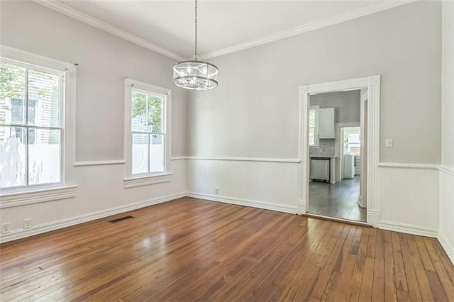 127 Rogers Ave, Macon, GA 31204 - empty room with a chandelier, wood-type flooring, a wainscoted wall, and ornamental molding