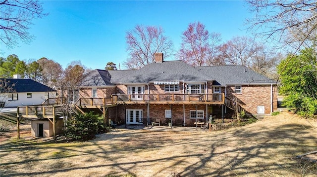 rear view of property featuring french doors, brick siding, a chimney, stairway, and a wooden deck