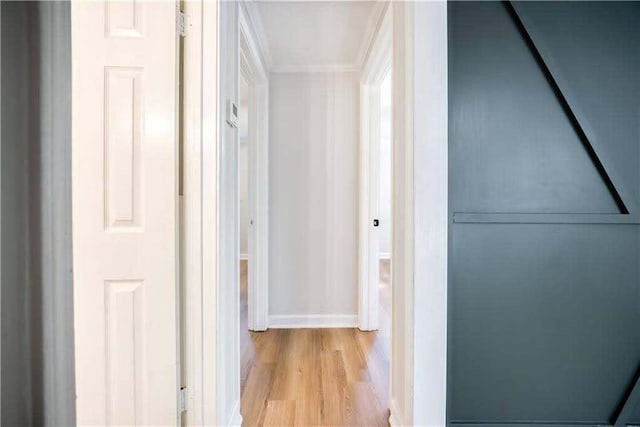 corridor with baseboards and wood finished floors