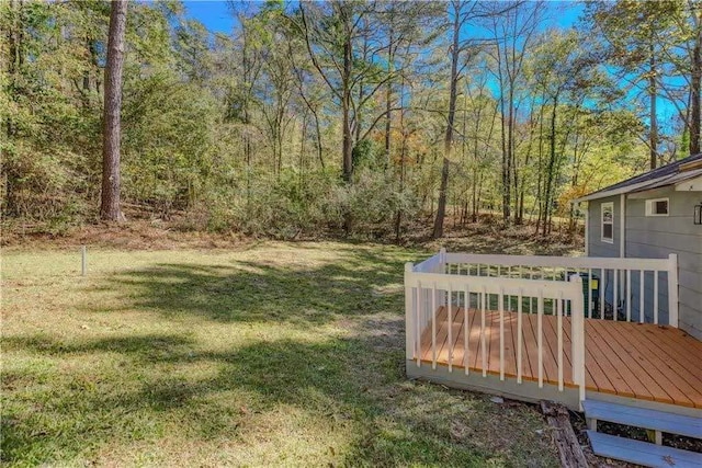view of yard featuring a view of trees and a deck