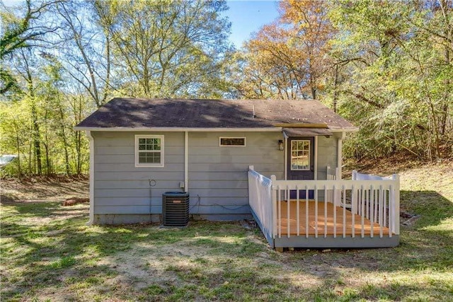 back of property with central air condition unit, a wooden deck, and roof with shingles