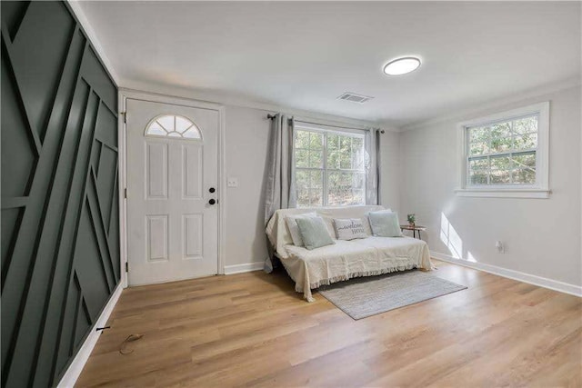foyer entrance with baseboards, visible vents, and light wood-style floors