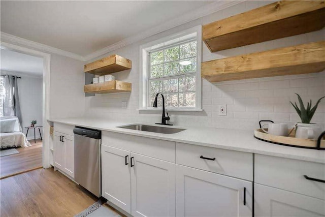 kitchen featuring open shelves, a sink, tasteful backsplash, stainless steel dishwasher, and ornamental molding