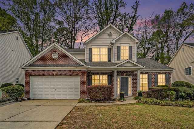traditional-style house with a front yard, brick siding, a shingled roof, an attached garage, and driveway