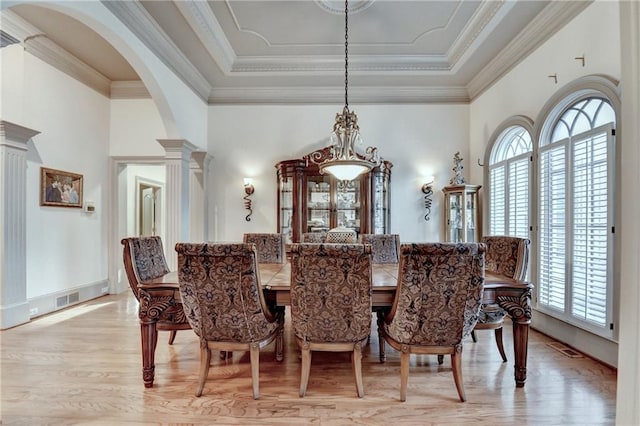 8455 Abingdon Ln, Duluth, GA 30097 - dining space featuring light wood-style floors, decorative columns, arched walkways, crown molding, and a towering ceiling