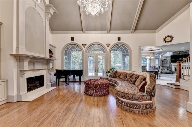 8455 Abingdon Ln, Duluth, GA 30097 - living area with a chandelier, high vaulted ceiling, a high end fireplace, light wood-style flooring, and french doors
