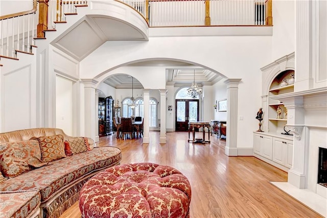 8455 Abingdon Ln, Duluth, GA 30097 - living area featuring decorative columns, arched walkways, light wood finished floors, a high ceiling, and ornamental molding