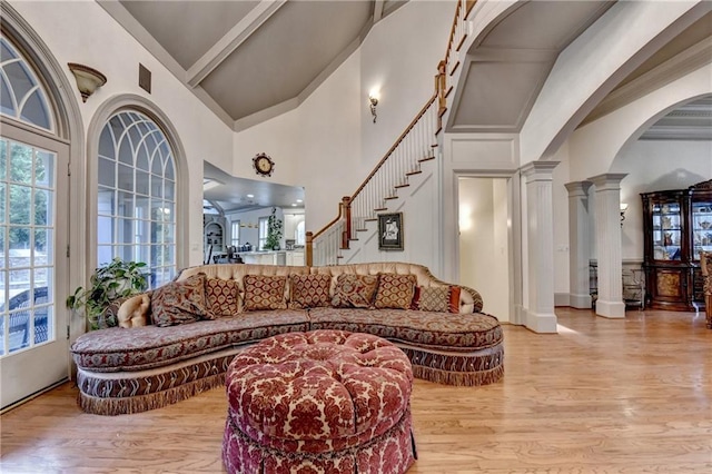 8455 Abingdon Ln, Duluth, GA 30097 - living room featuring high vaulted ceiling, wood finished floors, ornate columns, stairs, and arched walkways