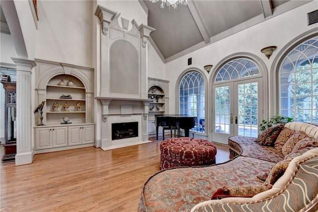 8455 Abingdon Ln, Duluth, GA 30097 - living room featuring high vaulted ceiling, a fireplace, french doors, light wood-style floors, and beam ceiling