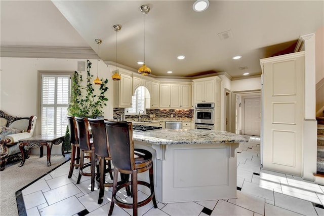 8455 Abingdon Ln, Duluth, GA 30097 - kitchen featuring light stone countertops, a breakfast bar area, crown molding, backsplash, and stainless steel appliances