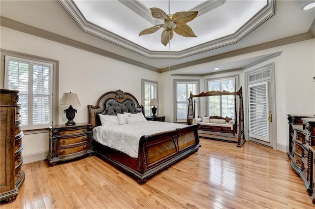 8455 Abingdon Ln, Duluth, GA 30097 - bedroom featuring multiple windows, ornamental molding, light wood-style flooring, and a tray ceiling