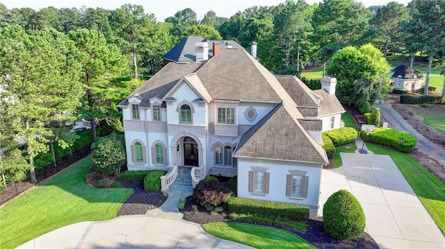 8455 Abingdon Ln, Duluth, GA 30097 - french country home featuring stucco siding, roof with shingles, and a chimney