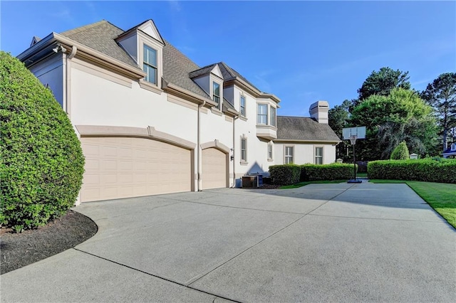 8455 Abingdon Ln, Duluth, GA 30097 - view of front of house featuring stucco siding, a garage, concrete driveway, a chimney, and a shingled roof