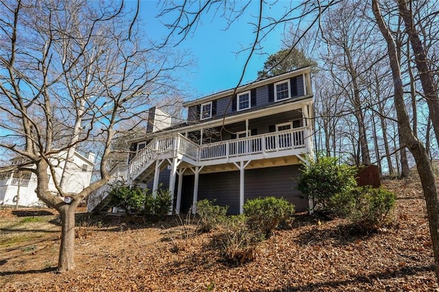 view of front facade with stairs and a chimney