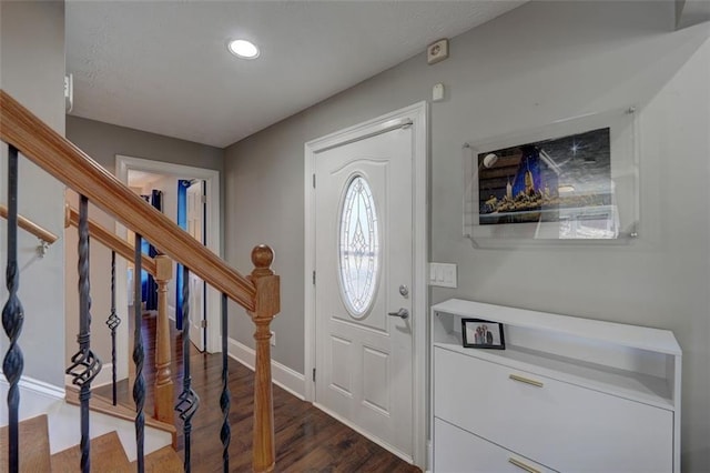 foyer featuring dark wood-style floors, baseboards, stairway, and recessed lighting