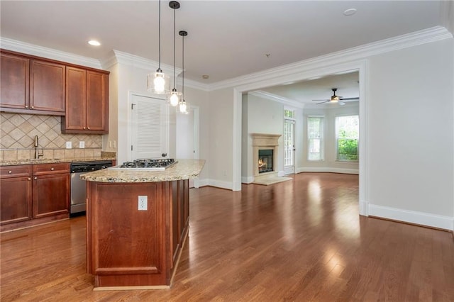 825 Highland Ln NE Unit 1116, Atlanta, GA 30306 - kitchen featuring appliances with stainless steel finishes, open floor plan, decorative backsplash, a glass covered fireplace, and a kitchen island