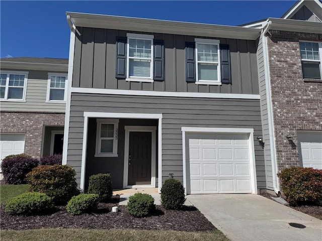 multi unit property with board and batten siding, a garage, concrete driveway, and brick siding
