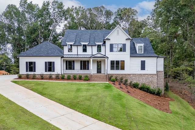 modern farmhouse style home featuring a front yard and covered porch