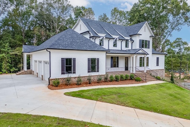 view of front of property featuring a garage, covered porch, and a front yard