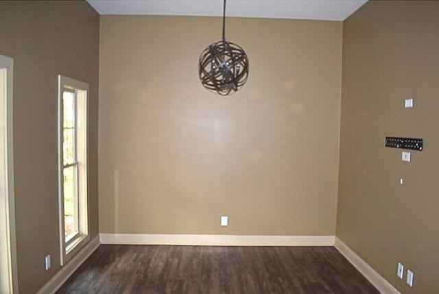 spare room with a wealth of natural light and dark hardwood / wood-style floors