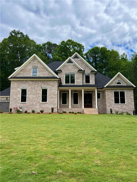 craftsman inspired home featuring a front yard, brick siding, and covered porch