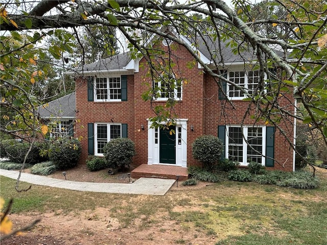 colonial house featuring a front lawn