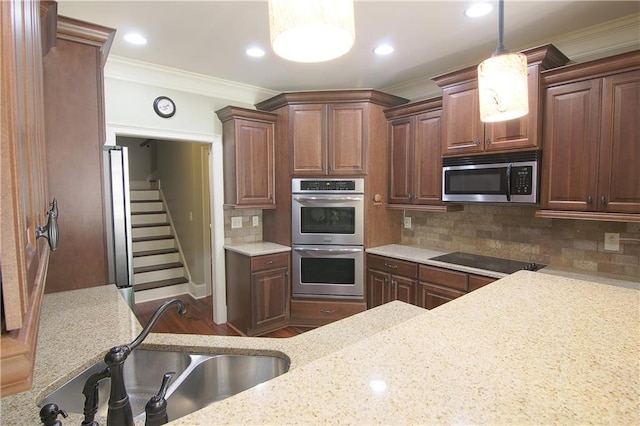 1520 Camden Cove Dr, Cumming, GA 30040 - kitchen with stainless steel appliances, a sink, crown molding, hanging light fixtures, and decorative backsplash