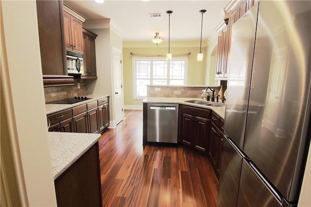 1520 Camden Cove Dr, Cumming, GA 30040 - kitchen with stainless steel appliances, a sink, backsplash, dark wood-style flooring, and ornamental molding