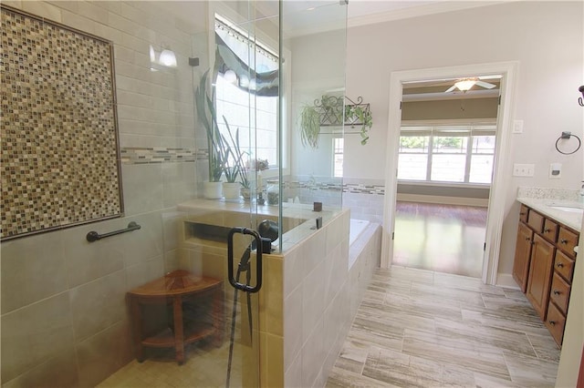 1520 Camden Cove Dr, Cumming, GA 30040 - bathroom featuring a shower stall, crown molding, vanity, ceiling fan, and a garden tub