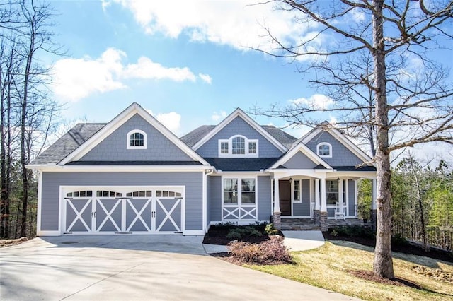 view of front of home with covered porch, driveway, and an attached garage