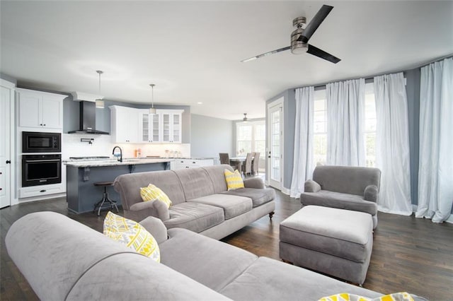 living room with a ceiling fan and dark wood-style flooring