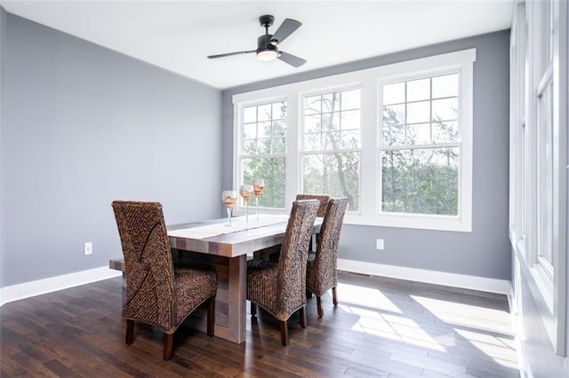 dining area featuring dark wood finished floors, a ceiling fan, and baseboards