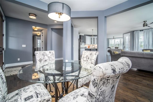 dining area featuring a ceiling fan, baseboards, and wood finished floors