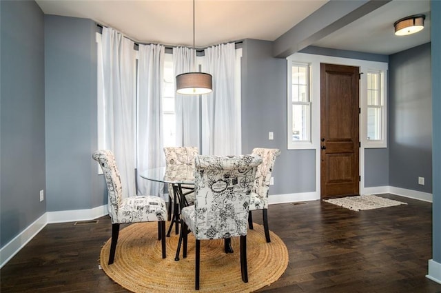 dining space featuring baseboards and wood finished floors