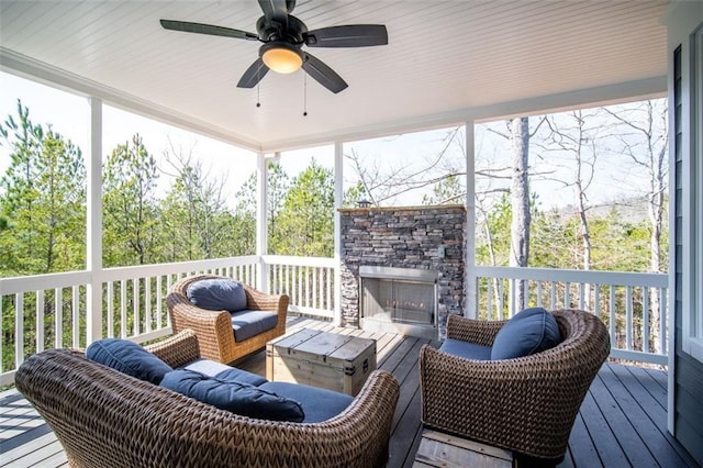 sunroom / solarium featuring a fireplace and ceiling fan